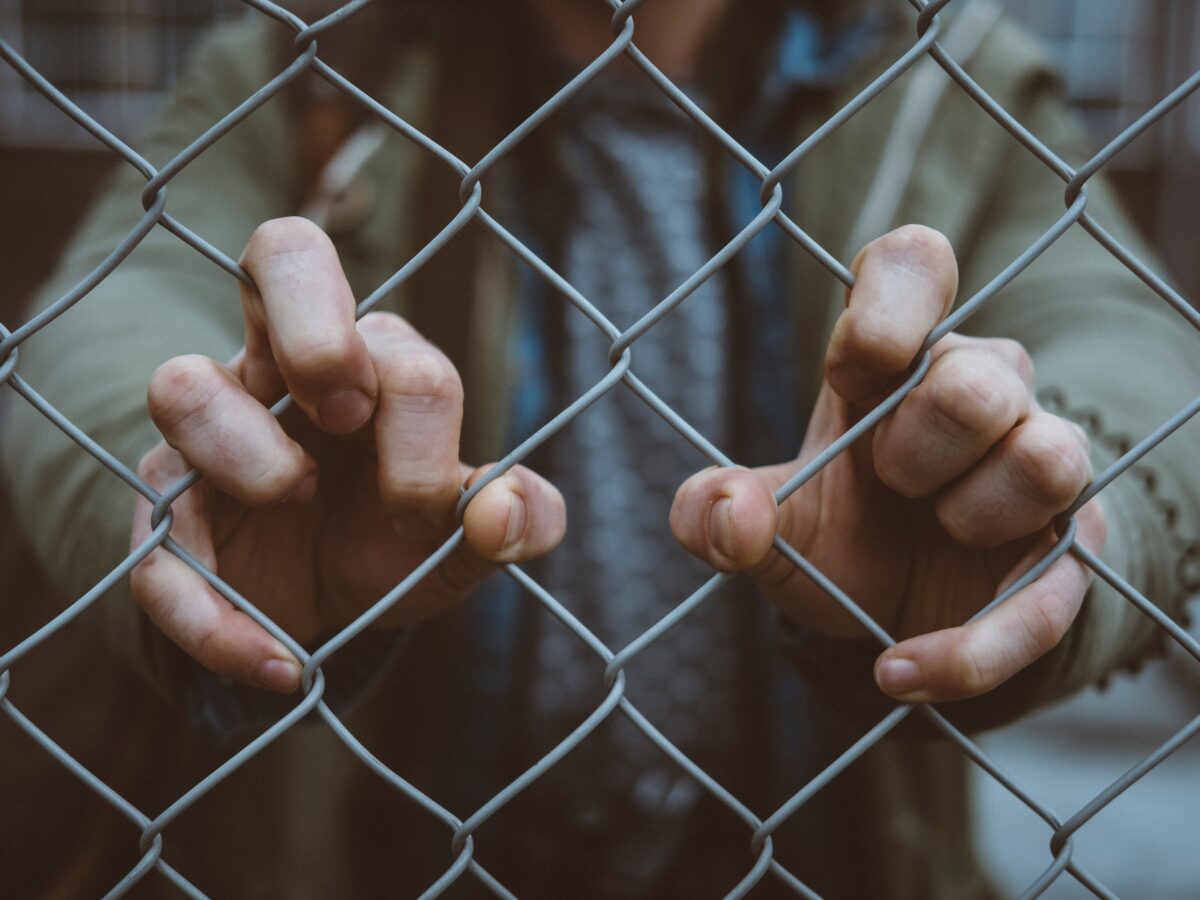 Going fit in mind, body, & connections with man holding a chain link fence