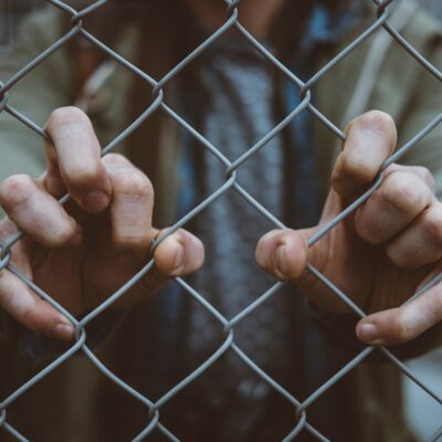 Going fit in mind, body, & connections with man holding a chain link fence
