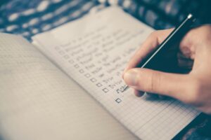 person checking off to do list as part of being productive and self-care