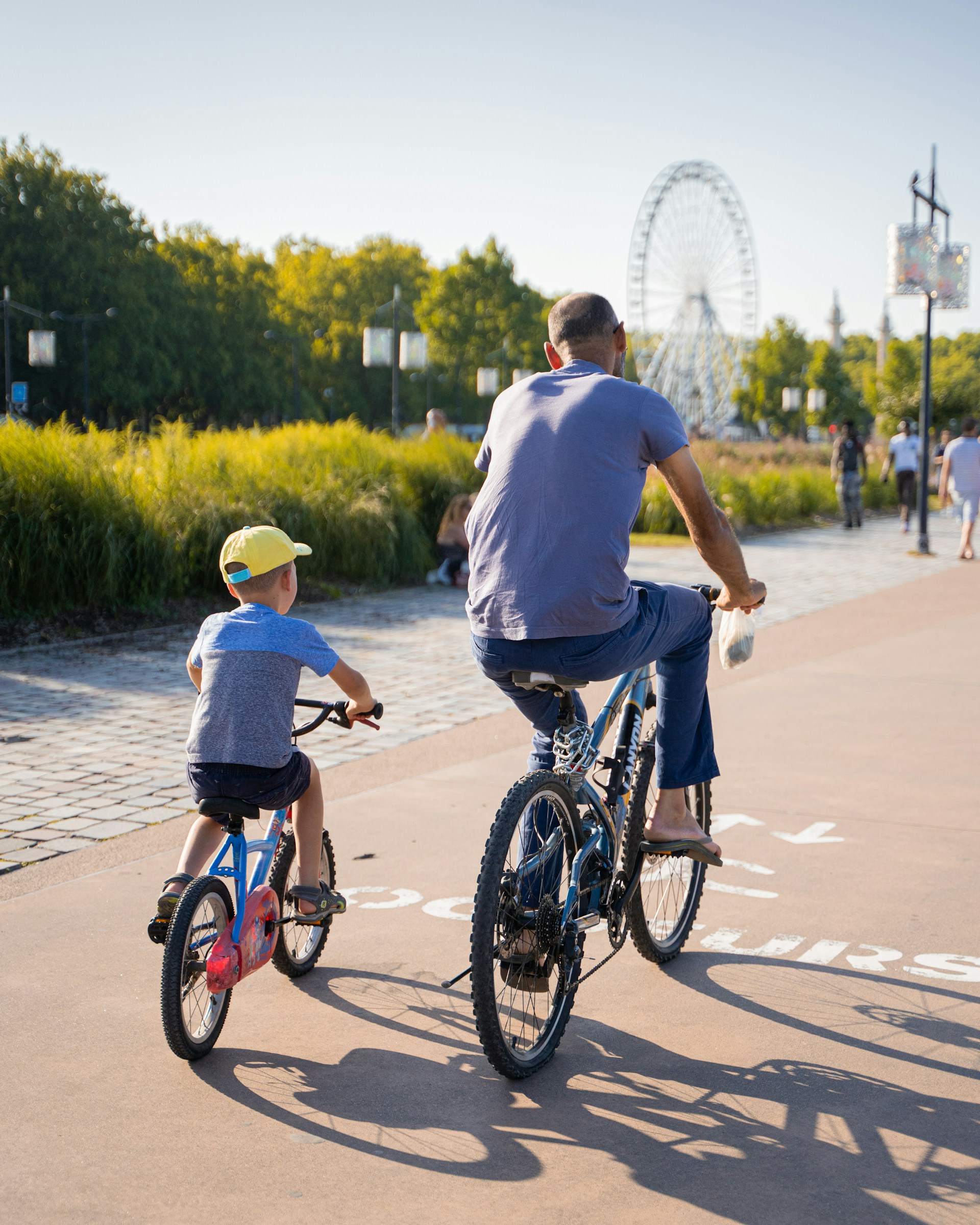 Dad and son biking together outdoors for family bonding